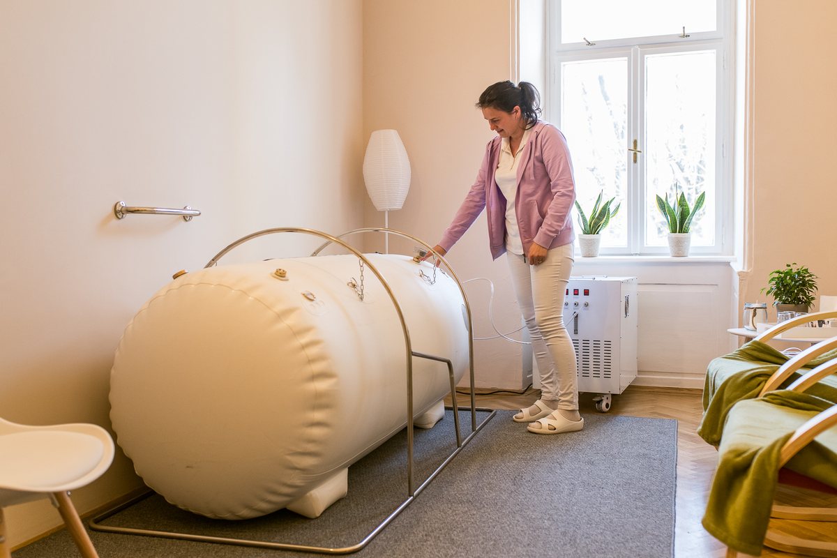 Žena pri hyperbarickej komore v miestnosti pracoviska